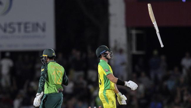 Australian batsman D'Arcy Short, right, tosses his bat in the air after he was run out by South African wicketkeeper Quinton De Kock during the ODI cricket match between South Africa and Australia in Paarl, South Africa, Saturday, Feb. 29, 2020. (AP Photo/Halden Krog)