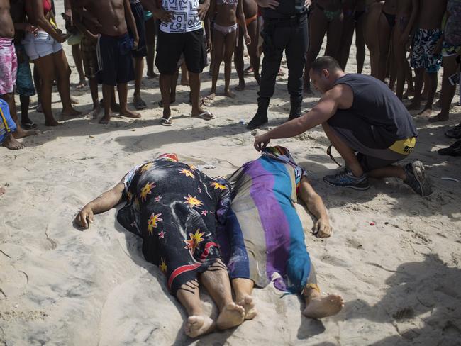 Joao Tinoco uncovers the face of his brother-in-law Eduardo Albuquerque who died when a bike lane collapse in Rio de Janeiro, Brazil, Thursday, April 21, 2016. Part of an elevated bike lane built ahead of the Olympic Games collapsed on Thursday, killing at least two people who were on it when cement gave way and crashed onto the beach below. (AP Photo/Felipe Dana)