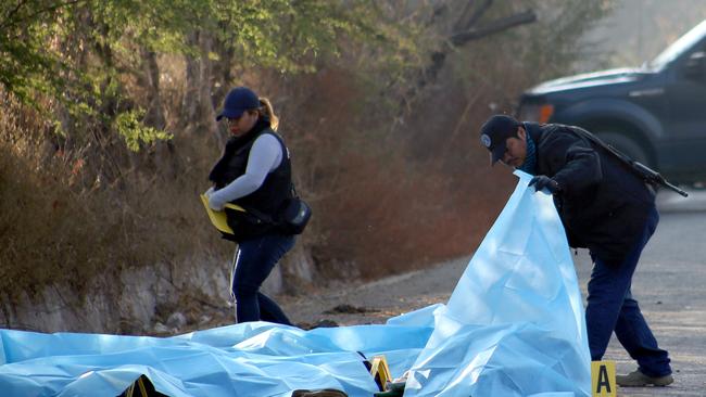 Mexican officers examine a site where six corpses were found on a road in Mochitlan, Guerrero State, last year. Picture: AFP