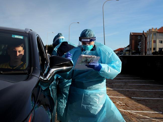 SYDNEY, AUSTRALIA - JULY 22: Milly Brown, Assistant in Nursing conducts a COVID-19 swab test as large crowds queue at a Bondi Beach drive-through testing clinic on July 22, 2020 in Sydney, Australia. New South Wales recorded 16 new COVID-19 cases on Wednesday, bringing the state's total number of coronavirus cases to 3,425. NSW residents are being urged to avoid non-essential travel and large crowds, as health authorities work to contain several COVID-19 cluster outbreaks across the state. Cases linked to the Crossroads Hotel, Thai Rock and Batemans Bay Soldiers Club clusters have been shown to all be linked to virus strains in Victoria, where residents are currently in lockdown due to the dramatic rise in community transmissions. (Photo by Lisa Maree Williams/Getty Images)