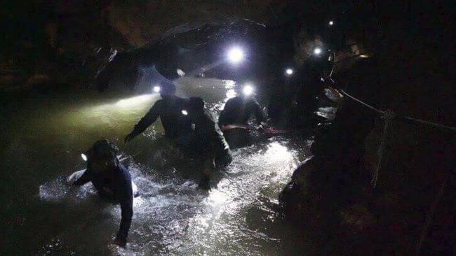 Thai rescue teams wade through the cave complex where 12 boys and their soccer coach went missing in Mae Sai, Chiang Rai province, northern Thailand. Picture: Tham Luang Rescue Operation Center via AP.