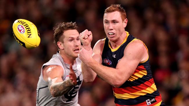 Tom Lynch fires off a handball despite pressure from Carlton’s Cam O’Shea. Picture: James Elsby/AFL Media/Getty Images