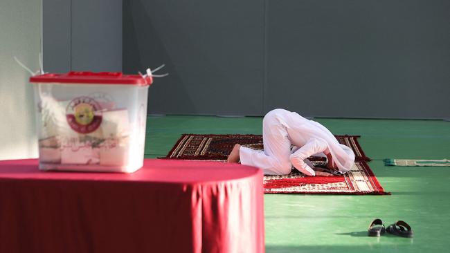 Snatching a prayer at a polling booth in Doha on Saturday. Picture: AFP