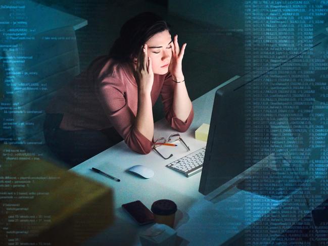 Shot of a young programmer working on computer code at night and looking stressed