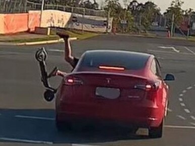 An e-scooter rider is thrown off his ride after smashing into a Tesla. Picture: Dash Cam Owners Australia