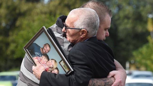 Ian Thomas, father of Bradley, holding a family photo, is comforted by a supporter at an earlier hearing. Photo: Sam Wundke