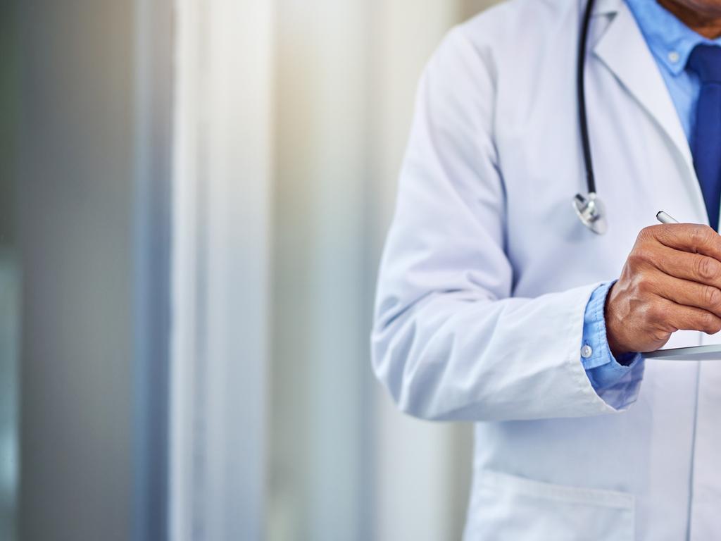 Shot of an unrecognizable male doctor writing on a digital tablet while standing inside of a hospital during the day    istock image