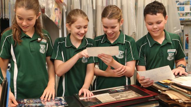 Kids at Freshwater State School look at old photo albums as the institution celebrates 100 years at their current address. Picture: Sandhya Ram