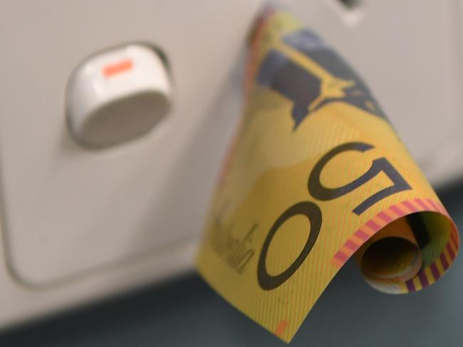 A $50 note is seen inserted into a power point in Melbourne, Monday, October 16, 2017. Malcolm Turnbull has been urged to squarely focus on making power cheaper as he seeks cabinet and party room support for a long-term energy policy. (AAP Image/Julian Smith) NO ARCHIVING