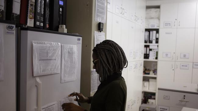 Pharmacist Mary Chindanyika looks at documents on a fridge containing a trial vaccine against HIV on the outskirts of Cape Town, South Africa. (AP Photo/Schalk van Zuydam, File)