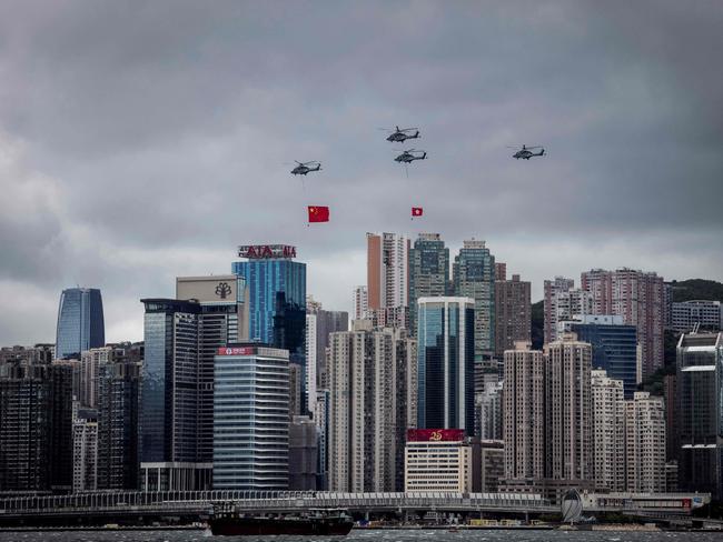 Helicopters fly Hong Kong and Chinese flags. Picture: Isaac Lawrence/AFP