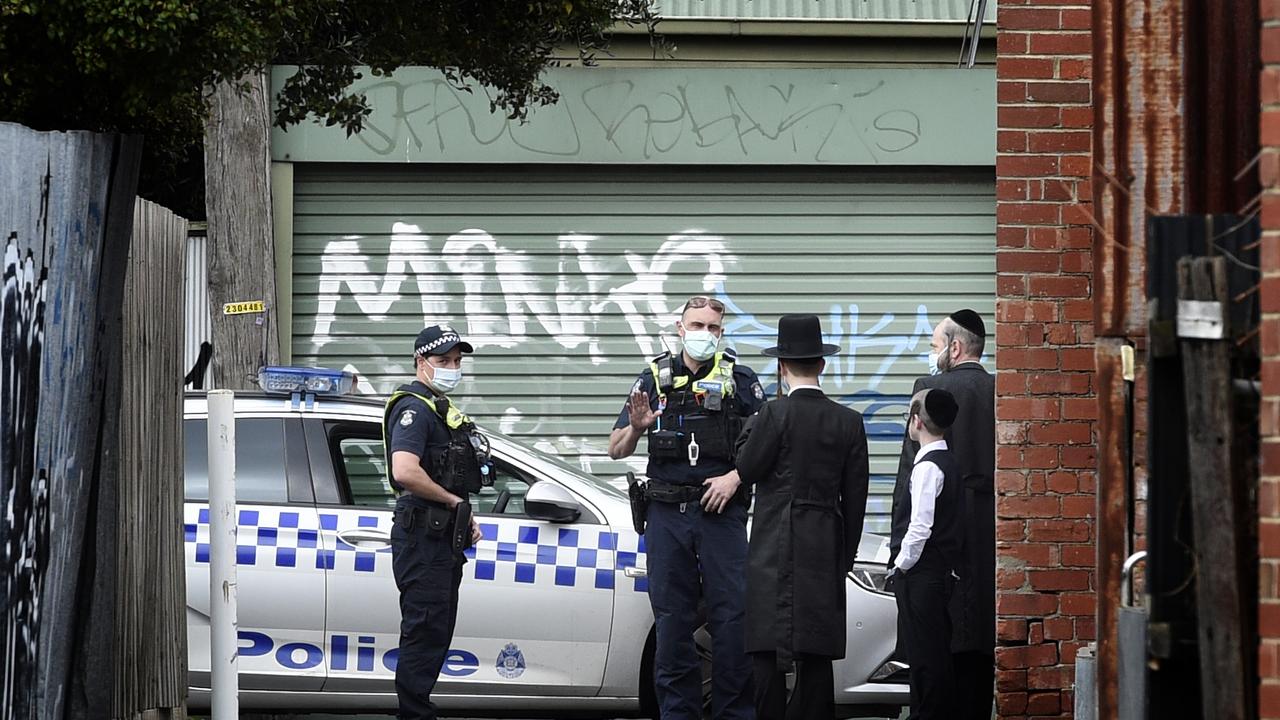 Police speak to locals near an illegal gathering at the Adass Israel Synagogue in Ripponlea. Picture: Andrew Henshaw