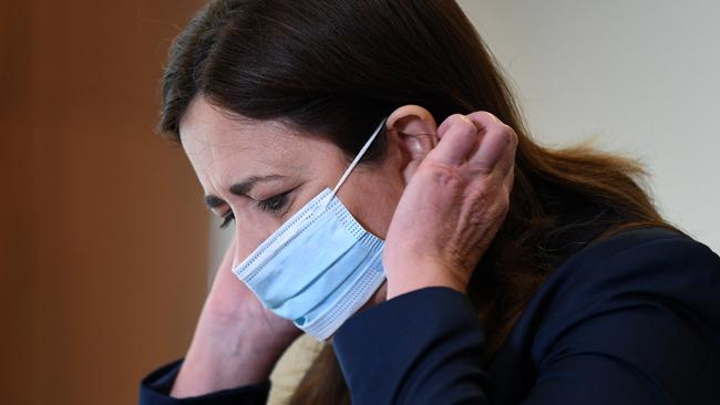 Queensland Premier Annastacia Palaszczuk slips on a face mask. Picture: NCA NewsWire/Dan Peled