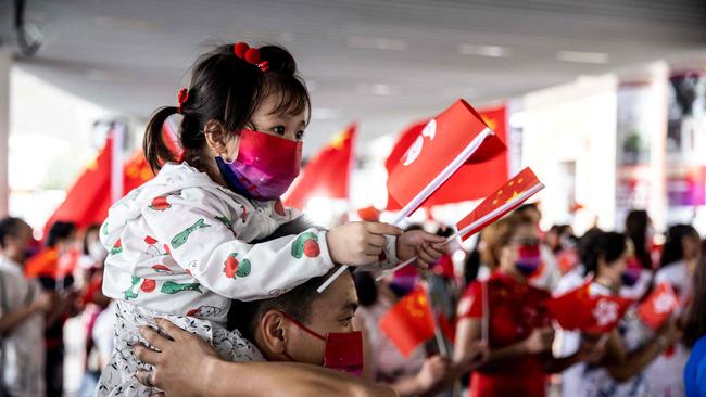 A young Hong Konger is lifted into the spirit of things on Friday. Picture: AFP