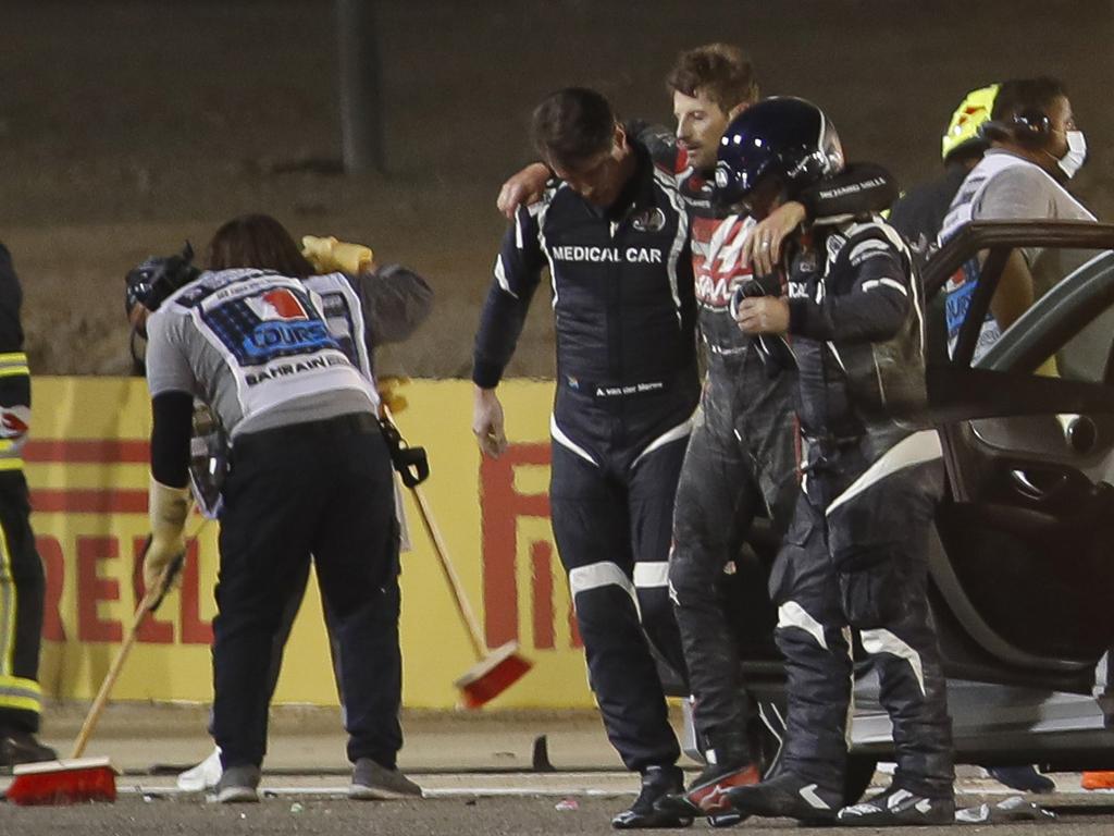 Stewards and medics attend to Haas F1's French driver Romain Grosjean after the crash.