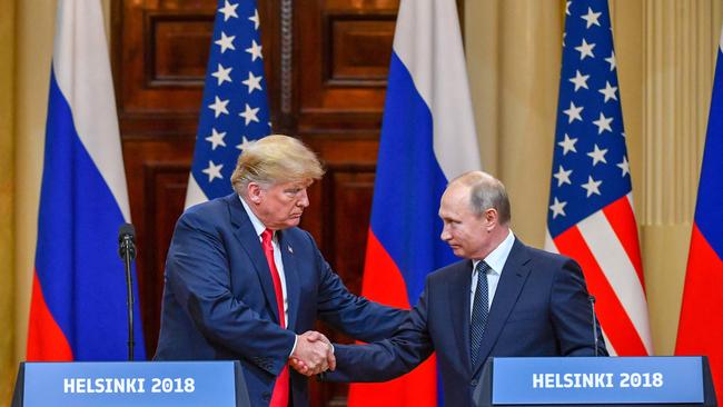 Donald Trump and Russia's President Vladimir Putin shake hands in Helsinki on July 16, 2018.