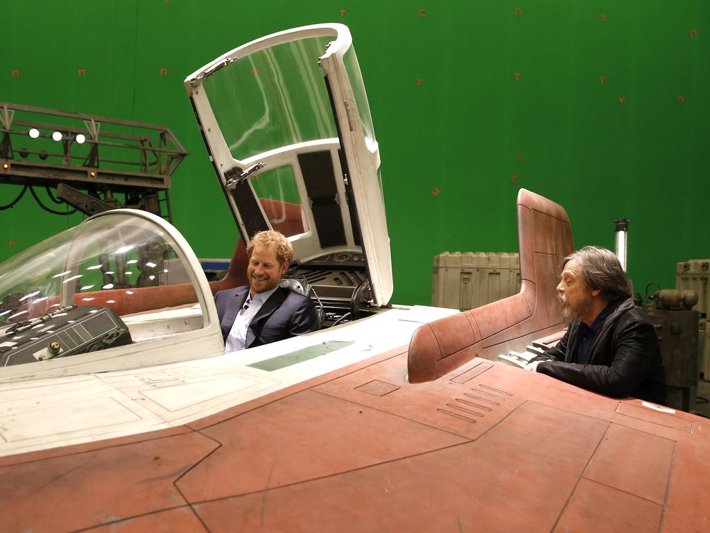 Prince Harry sits in an A-wing fighter as he talks with US actor Mark Hamill during a tour of the Star Wars sets at Pinewood studios on April 19, 2016 in Iver Heath, England. Picture: Getty