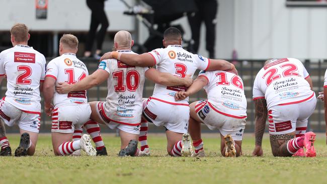 Roosters players took a knee before last week’s clash with Dora Creek. Photo: Sue Graham