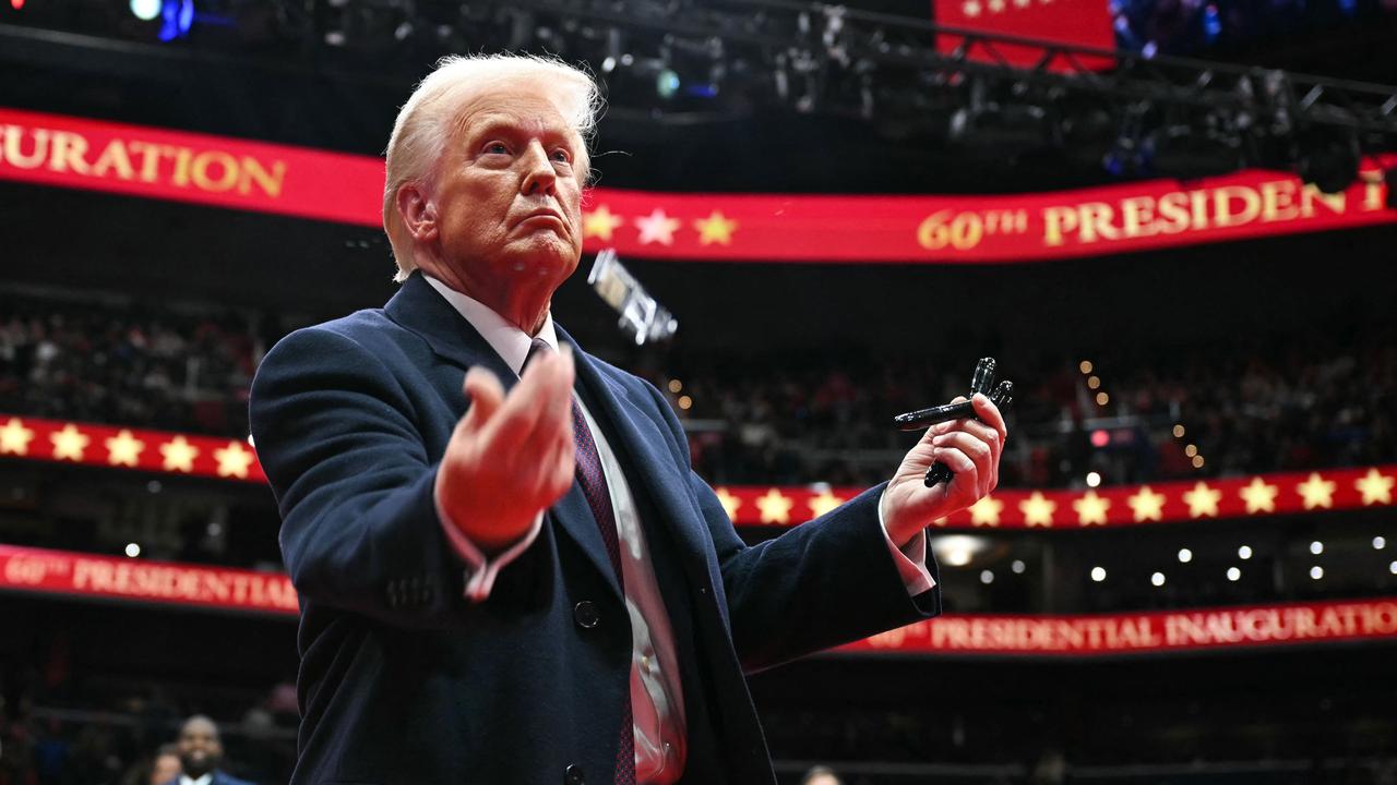 US President Donald Trump throws pens to the crowd after signing executive orders in Washington this week. Picture: AFP