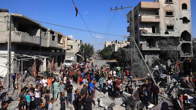 Palestinians gather at the site of a collapsed and damaged buildings following an Israeli airstrike in Rafah, in the southern of Gaza Strip. Picture: AFP