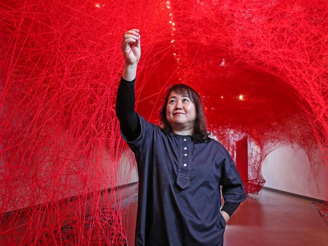 Chiharu Shiota with her her installation called Uncertain Journey which is part of her exhibition at GOMA.  Picture: Zak Simmonds