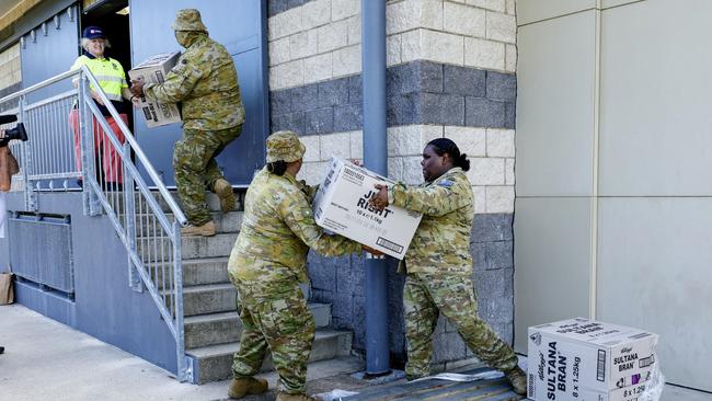 Australian Army personnel unload a pallet of donated breakfast cereal at the Cooktown PCYC. The entire community has been evacuated following the flood emergency, with the majority of the town staying at the Cooktown PCYC, which is set up as an evacuation centre by the Australian Red Cross. Picture: Brendan Radke