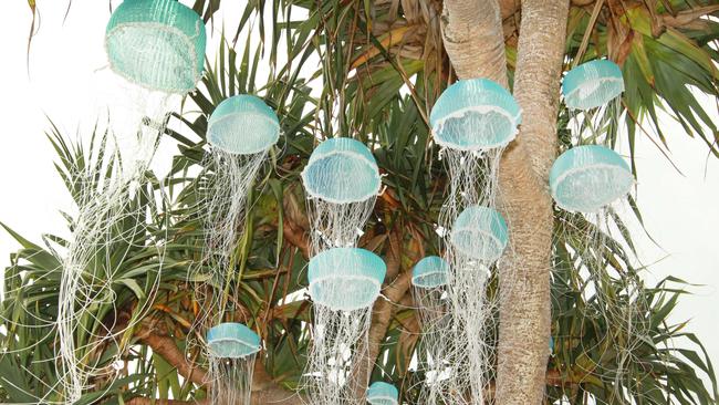 Crowds and People looking at art at the Swell sculpture festival held on Currumbin Beach . at art by Melissa Hirsch called Jellyfish Tree . Picture Mike Batterham