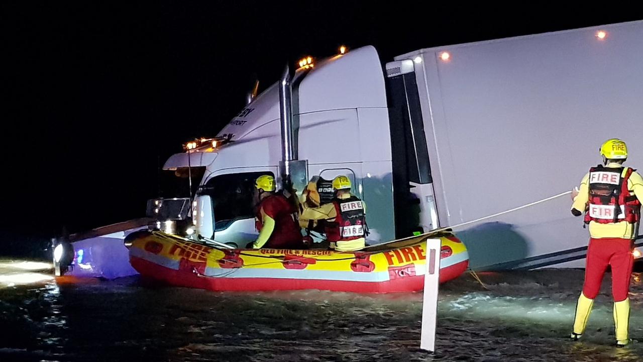 A truck driver was rescued from floodwaters by emergency crews after rolling on a Goondiwindi highway. Picture QFES Media