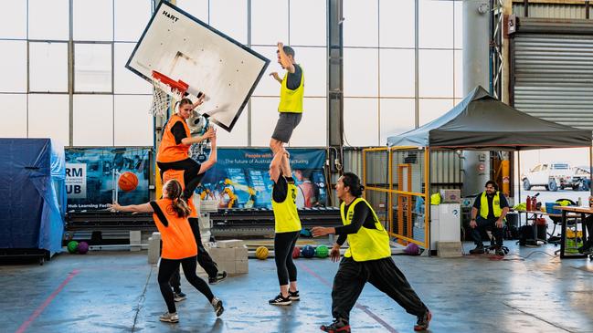 Students try to score against a moving basketball hoop controlled by a robotic arm at the Advanced Robotics for Manufacturing Hub.