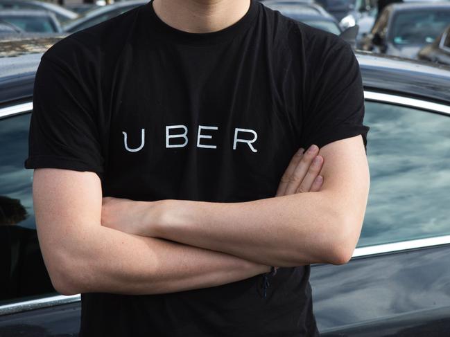 (FILES) This file photo taken on February 09, 2016 shows a man wearing a shirt displaying the logo of smartphone ride service Uber during a protest at the Place de la Nation in Paris. Uber announced on December 1, 2016 that it would increase its rates from 10 to 15 percent in France. / AFP PHOTO / Geoffroy Van der Hasselt