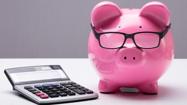 Close-up Of A Piggybank With Eyeglasses And Calculator On Desk; investing superannuation money calculations generic