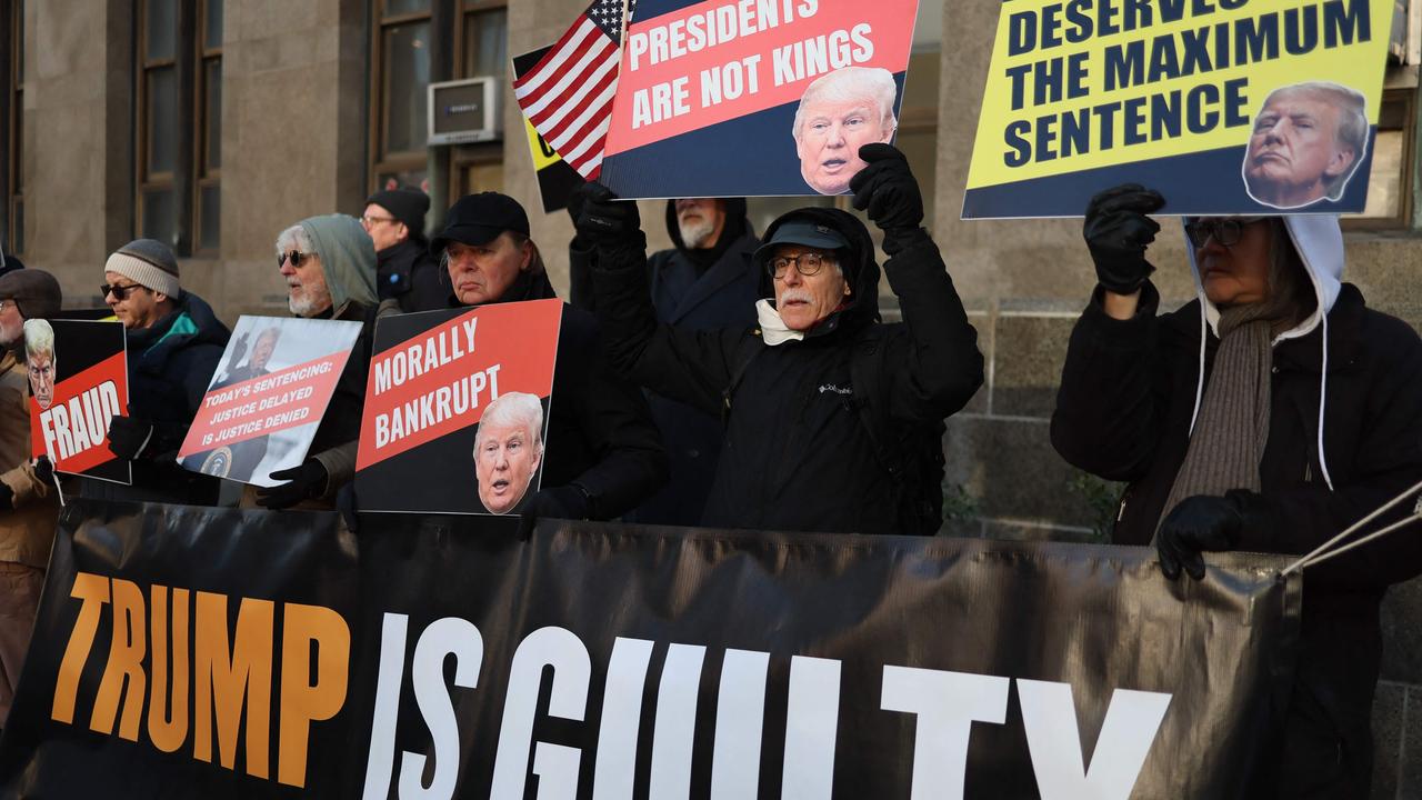 Anti-Trump protesters hold signs outside the Manhattan Criminal Court. Picture: Charly Triballeau/AFP