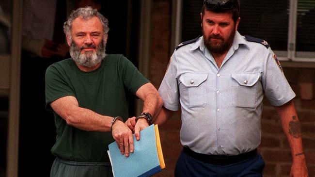 Colin Fisk, pictured here being led out of Goulburn police station in 1997, has been charged with historical sex offences against a boy on the northern beaches. Picture: News Corp.