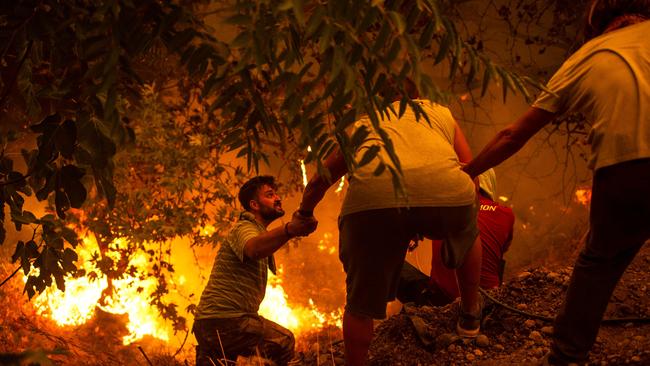 Villagers join the fight in village of Gouves on Evia on Sunday. Picture: AFP