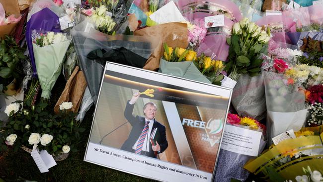 A photograph of David Amess is seen amid floral tributes left at the scene of the fatal stabbing. Picture: AFP