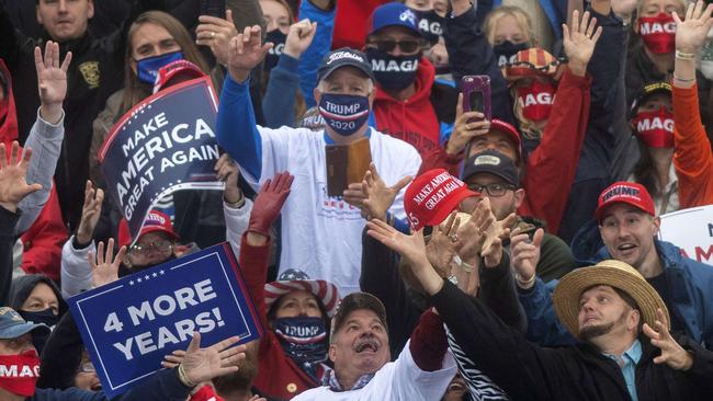 Trump supporters strain to catch a Make America Great Again hat thrown by Donald Trump in Lititz, Pennsylvania. Picture: AFP