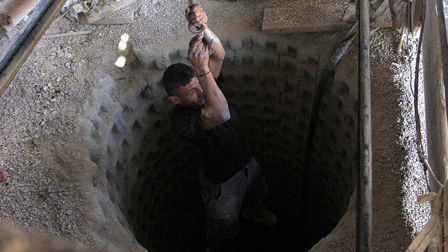 A Palestinian worker is lowered on a rope into a smuggling tunnel dug beneath the Gaza-Egypt border in the southern Gaza Strip in 2013. Picture: Said Khatib/AFP