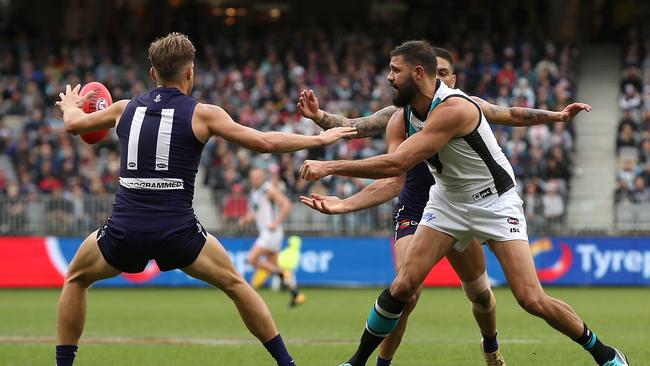 Port Adelaide’s Patrick Ryder handballs bewteen two Fremantle Dockers at Optus Stadium. Picture: Paul Kane/Getty