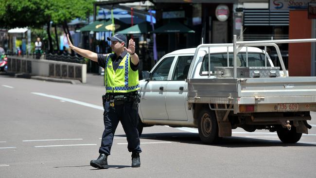 Sgt Ronald Mummery directs traffic at the Mitchell and Knuckey st intersection after an explosion in the Harvey st sub station created an almost city wide blackout.