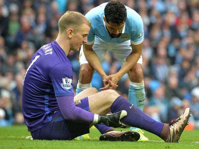 Manchester City's Joe Hart holds his calf.