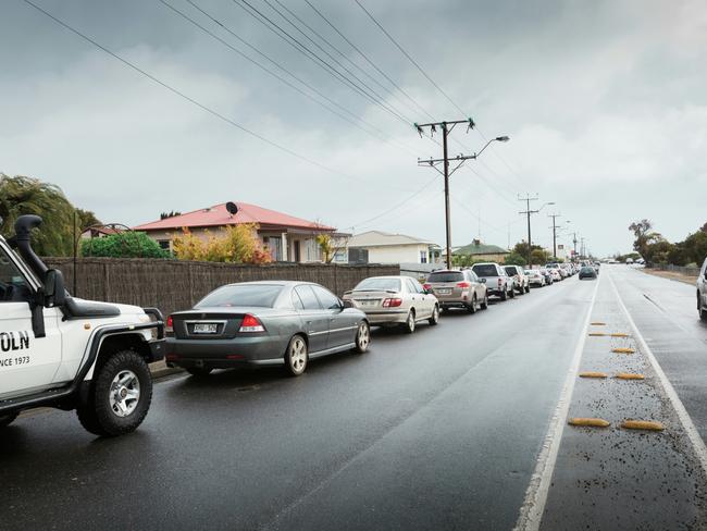 Port Lincoln residents line up in record numbers outside the only service station operating in town. Picture: Robert Lang