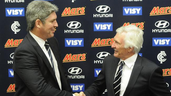 Newly appointed Carlton coach Mick Malthouse (right) and club president Stephen Kernahan shake hands after a media conference at Visy Park in 2012.