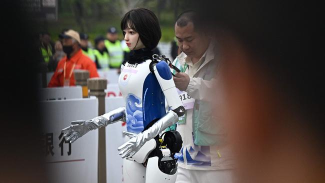 A robot takes part in the humanoid robot half marathon in Beijing on April 19, 2025. Dozens of humanoid robots took to the streets of Beijing, joining thousands of their flesh-and-blood counterparts in a world-first half marathon showcasing China's drive to lead the global race in cutting-edge technology. (Photo by Pedro Pardo / AFP)