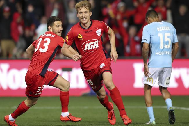 Adelaide United’s Ben Halloran scores the winning goal with Apostolos Stamatelopoulos and Melbourne City’s Kearyn Baccus watching in the A-League elimination final at Coopers Stadium. Picture SARAH REED