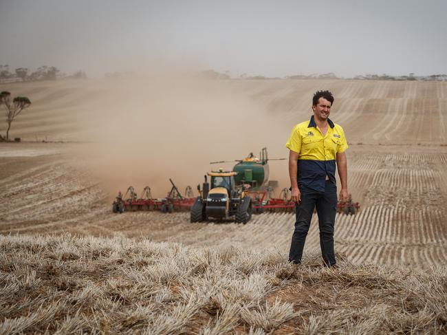 James Venning standing in one of his paddocks with farm worker Paul Harvie sowing canola at their Bute property. Picture: Matt Turner