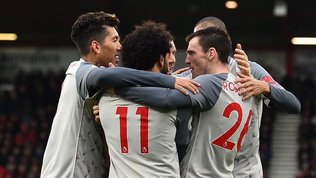 Liverpool players mob Andrew Robertson after his cross is steered into his own net by Bournemouth defender Steve Cook.