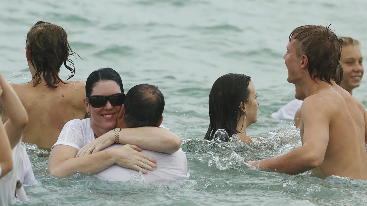 Parents of Balin Stewart, Kerri-Lyn and Michael, embrace in the water at their son’s tribute on his home beach at Buddina. Picture: Lachie Millard