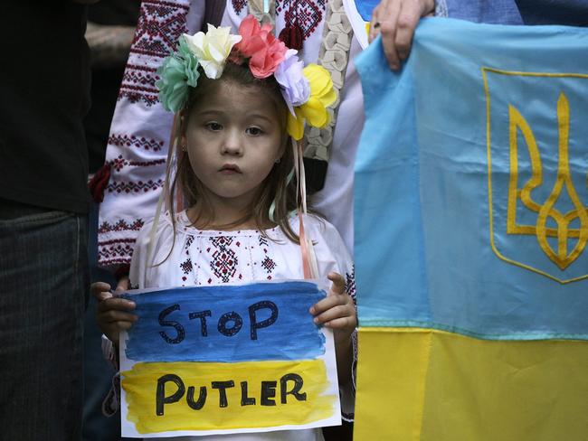 A girl member of the Ukranian community holds a sign reading "Stop Putler" (Putin+Hitler) during a protest outside of the Russian embassy in Buenos Aires. Picture: AFP