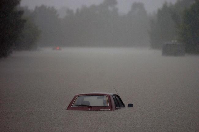 Gold Coast, June 30, 2005. A submerged vehicle on a flooded main road at Robina on Queensland’s Gold Coast today. Widespread flooding has hit the popular tourist area, known for its sunshine and sandy beaches, with reports of rainfall reaching 80mm per hour in some regions. (AAP Image/Tony Phillips)