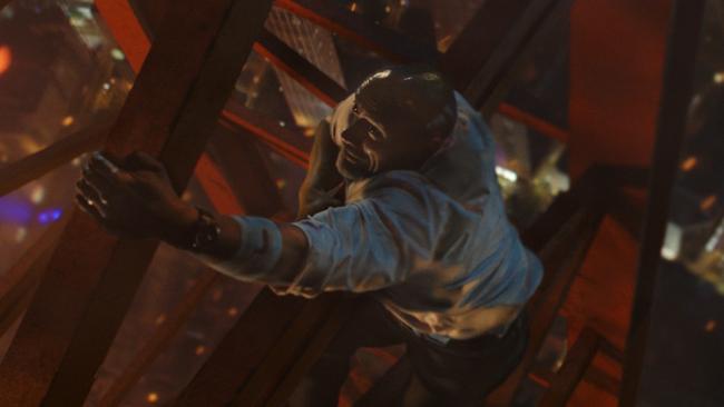 Dwayne Johnson climbs a construction crane in a scene from film Skyscraper